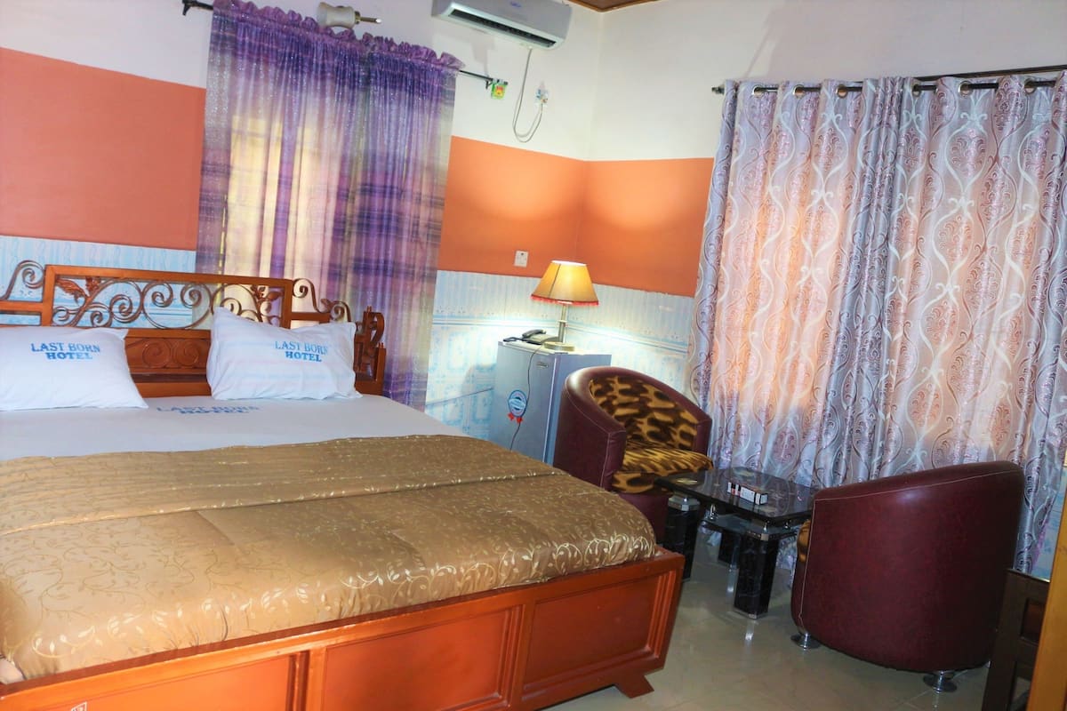 Habitación de hotel con cama, escritorio, silla y lámpara.