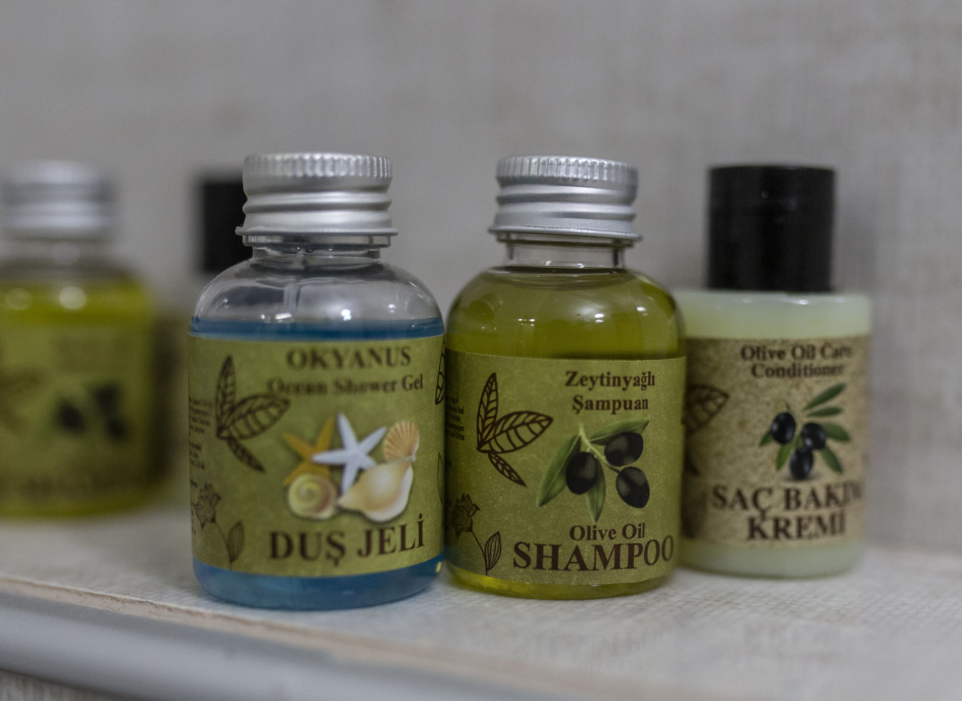 Tres botellas de productos para el cuidado del cabello en un estante.