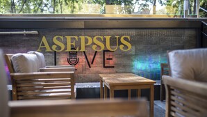 Un rincón acogedor con mobiliario de madera y una pared con el texto "ASEPSUS LIVE".