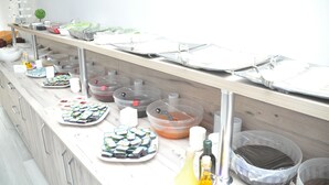 Montaje de bufé con diversos alimentos y recipientes.