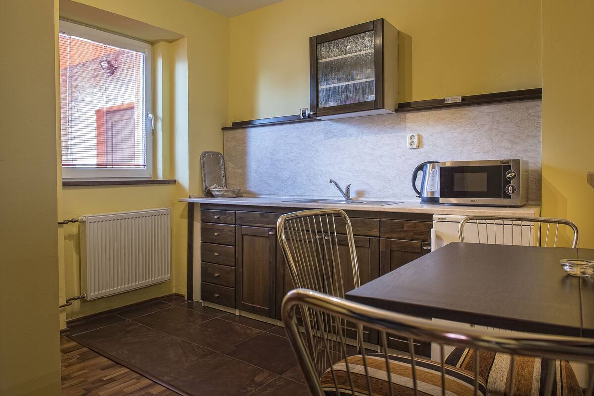 A compact kitchen with a microwave, a kettle, and a sink.