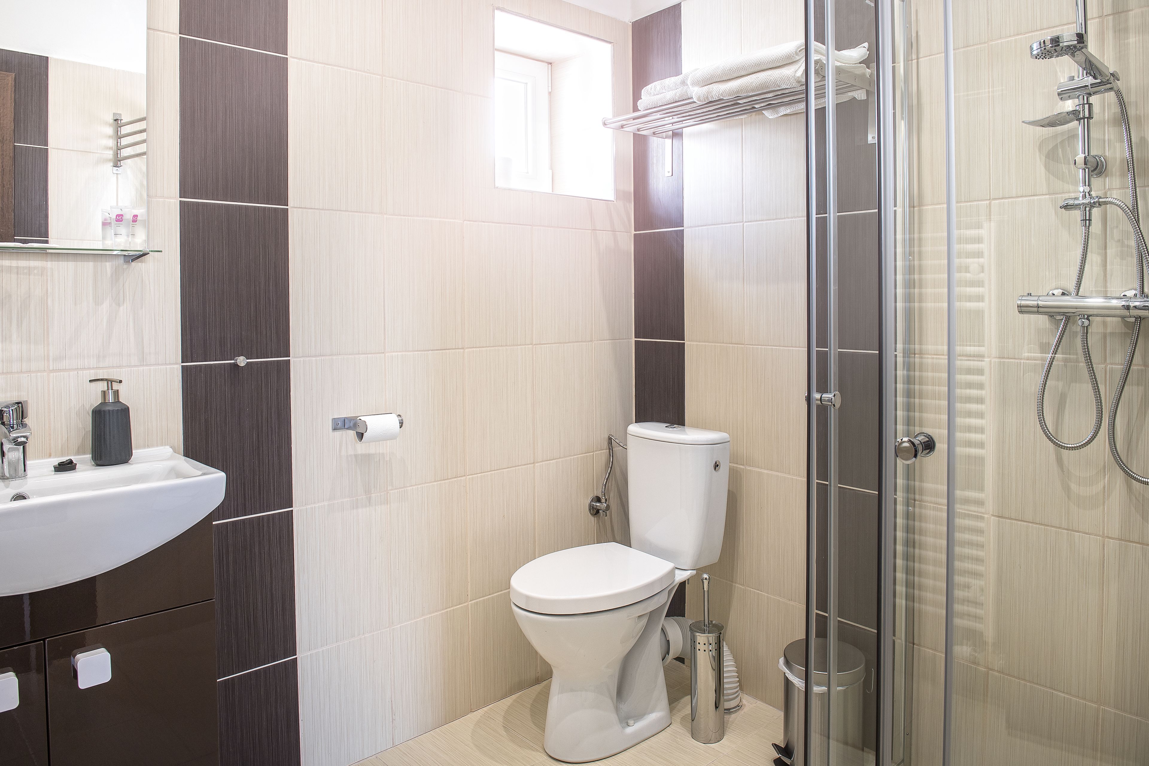 Ein modernes Badezimmer mit Toilette, Waschbecken und Duschkabine aus Glas.