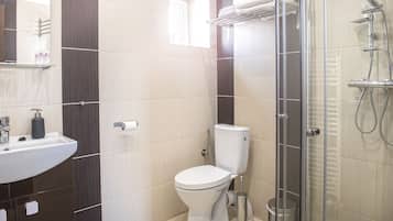 Ein modernes Badezimmer mit Toilette, Waschbecken und Duschkabine aus Glas.