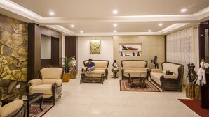 A spacious living room with multiple seating options, including sofas and armchairs, arranged around a central coffee table. - Daizzo Maple Residency (Gangtok)