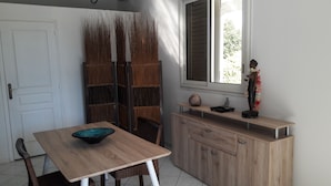 Un comedor con una mesa de madera, sillas y un aparador con adornos.