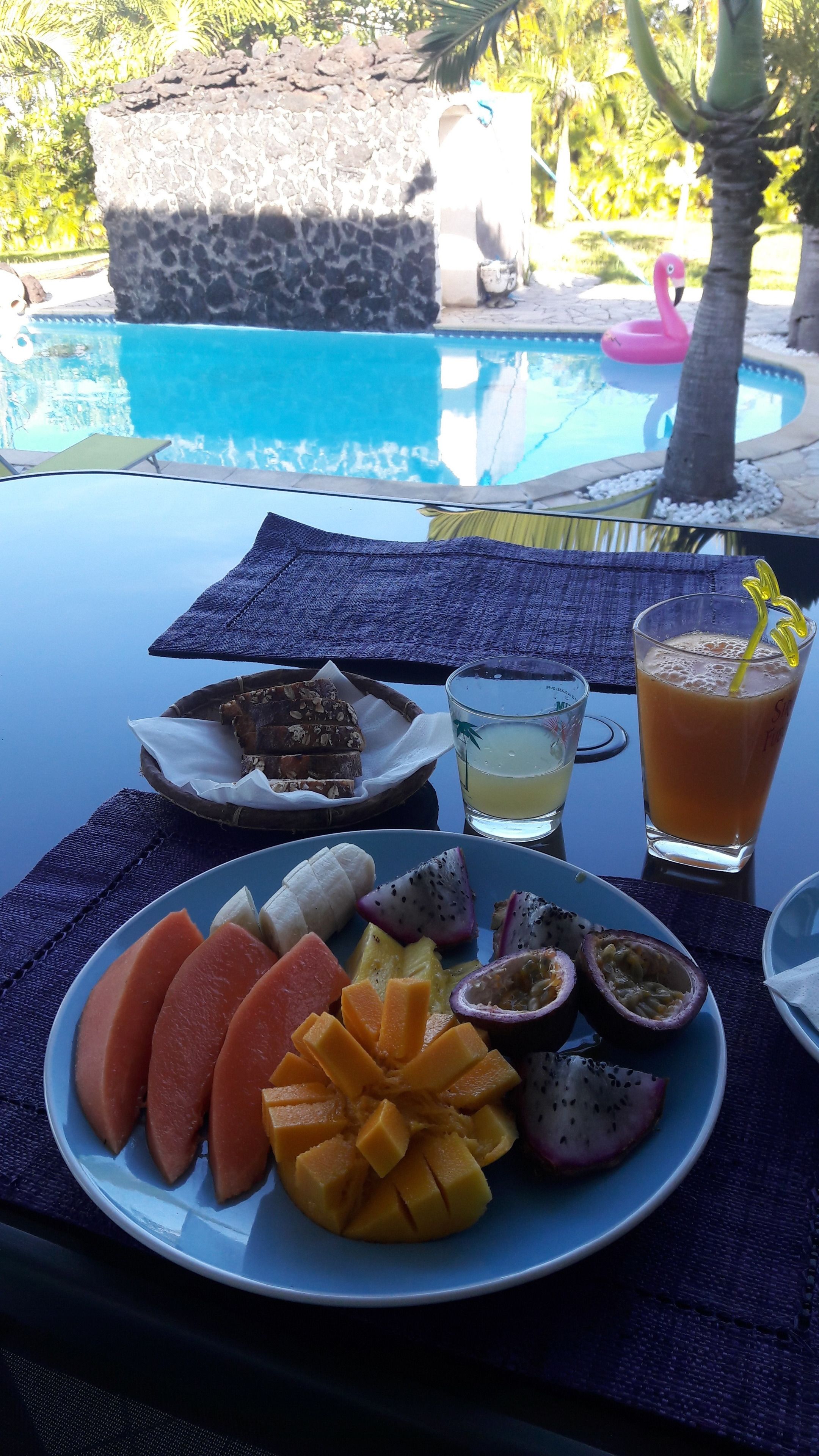 Une table avec une assiette de fruits, un verre et une collation.