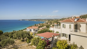 A coastal residential area with houses, a clear blue sky, and a view of the sea.