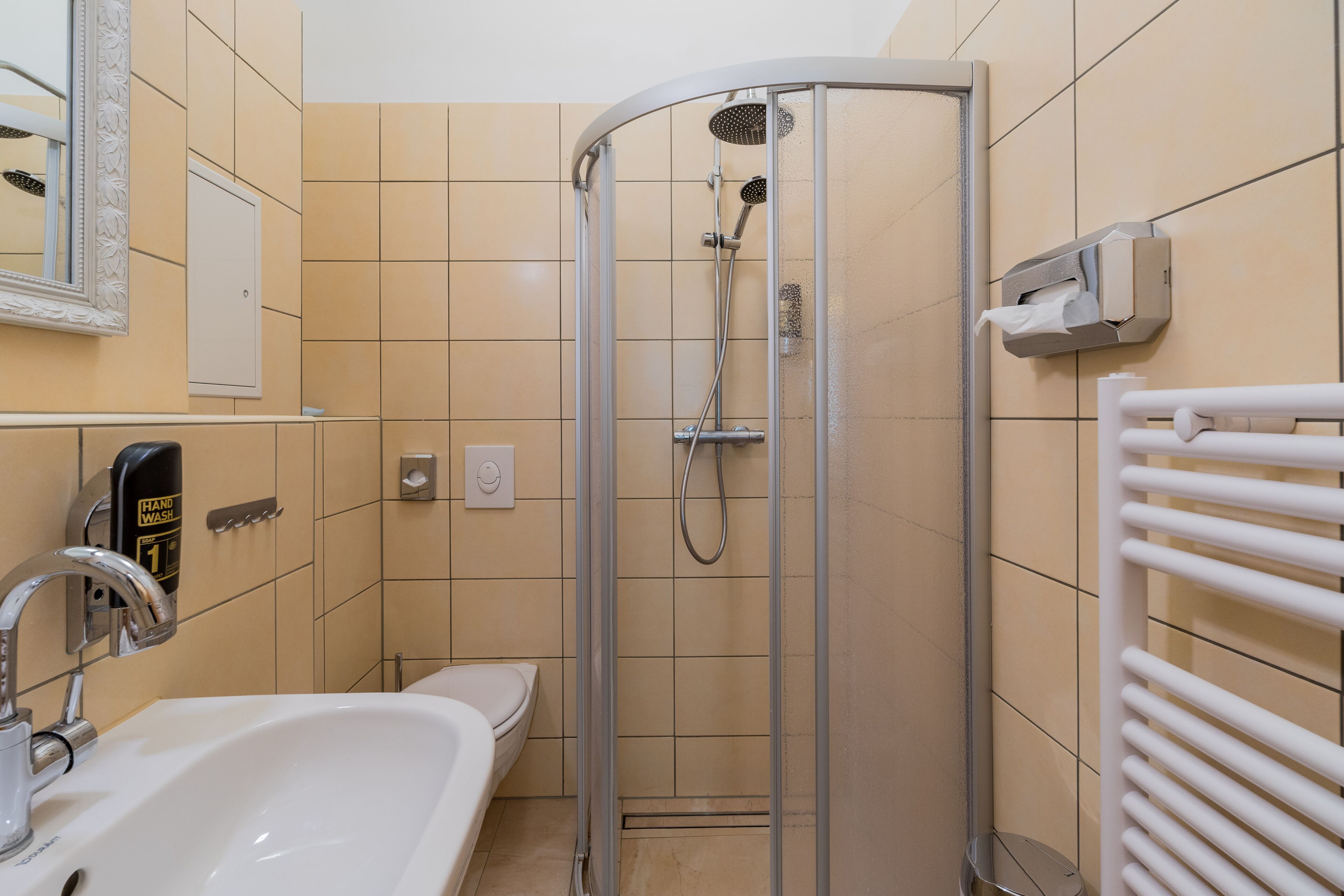 A bathroom with a shower, sink, and toilet.