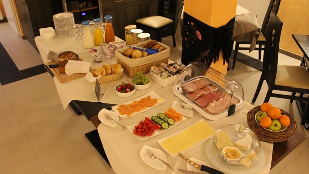 A breakfast buffet with various food items and utensils. - Hotel Restaurante Lorca (Weinsberg)