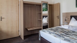 A hotel room with a large bed, a wardrobe with a mirror, and a ceiling light. - Hotel Restaurante Lorca (Weinsberg)