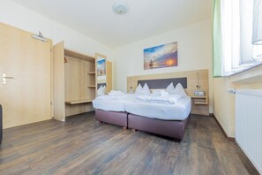 A hotel room with a bed, a wardrobe, a painting, and a window. - Hotel Restaurante Lorca (Weinsberg)