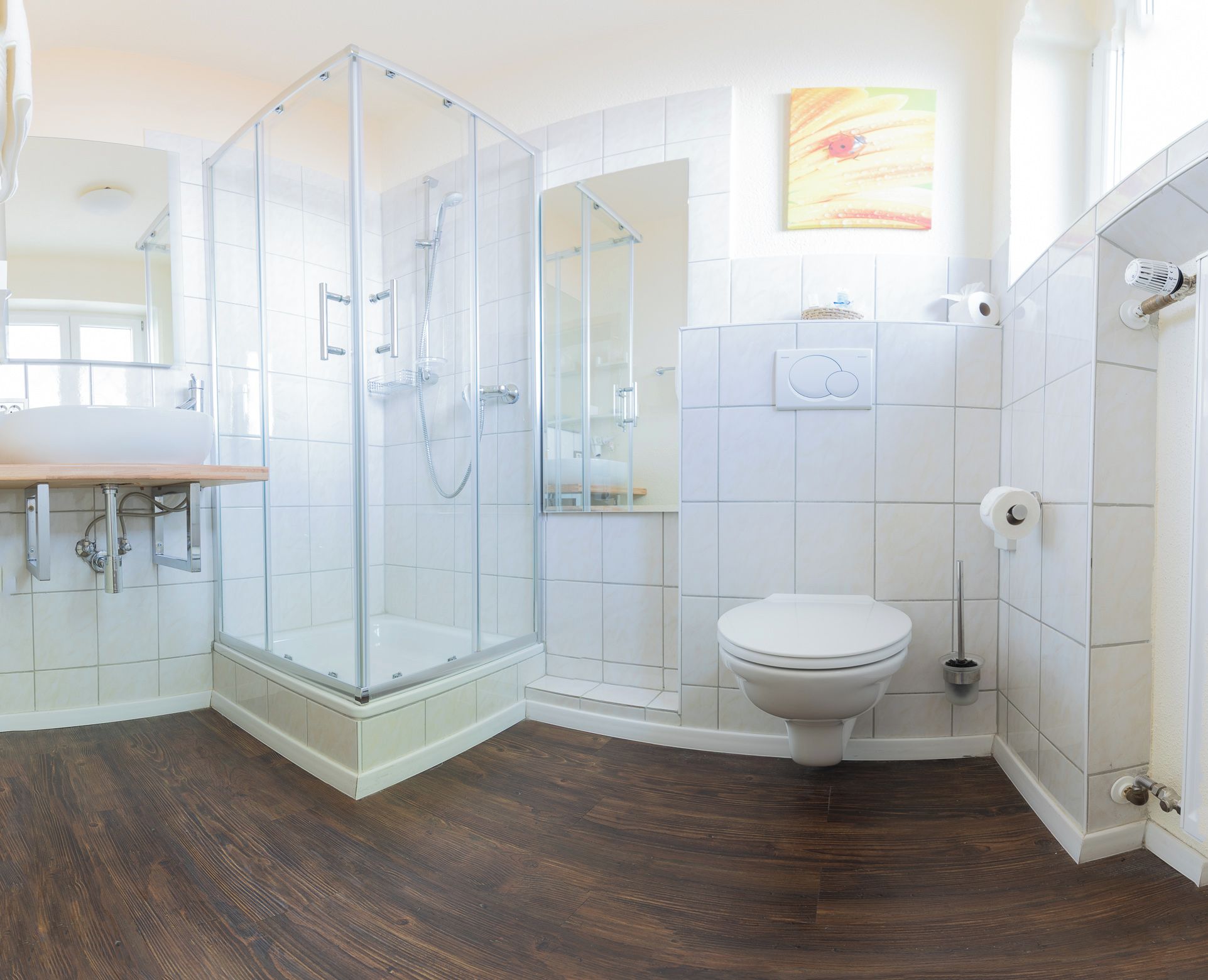 Une salle de bain moderne avec une douche à parois de verre, des toilettes et un lavabo.