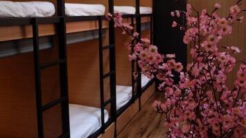 A bunk bed room with wooden walls and a ceiling light fixture.