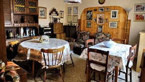 A dining area with wooden furniture, a piano, and a wall decorated with framed pictures. - B&B Il Cantastorie Casa Molinari-Boldrini (Castelfranco Emilia)