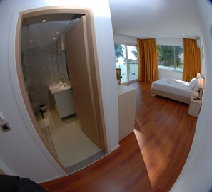 Suíte, sacada, vista para o mar | Área de estar | TV de tela plana