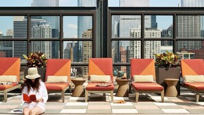 A rooftop pool area with lounge chairs and a view of the city skyline. - The Hoxton, Chicago (Chicago)