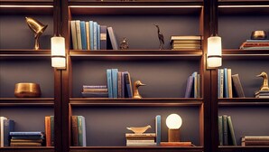 A cozy reading area with a dark blue sofa, multiple bookshelves, and a small table with a drink and a glass. - The Hoxton, Chicago (Chicago)