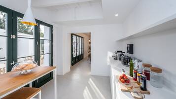 Una cocina moderna con encimera de madera, una exhibición de pan y diversos electrodomésticos.
