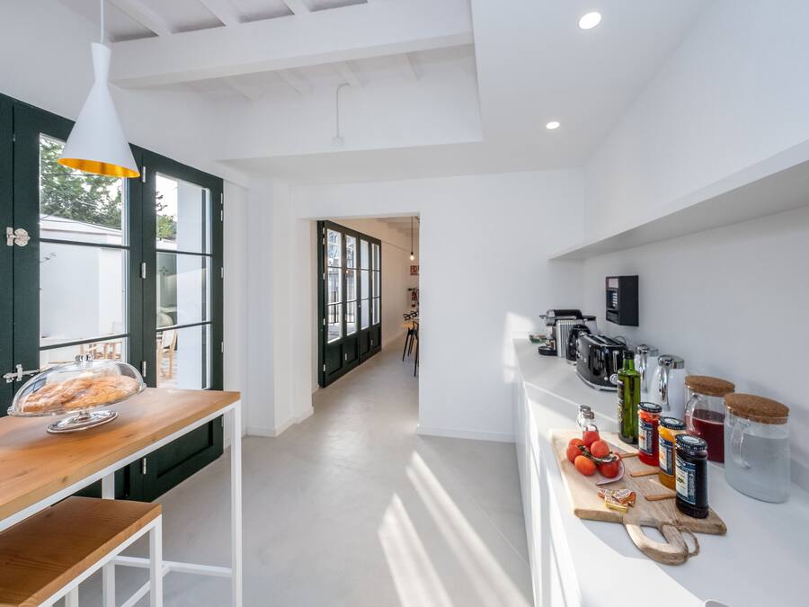 Una cocina moderna con encimera de madera, una exhibición de pan y diversos electrodomésticos.
