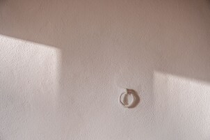 Una pared con textura y una marca circular.