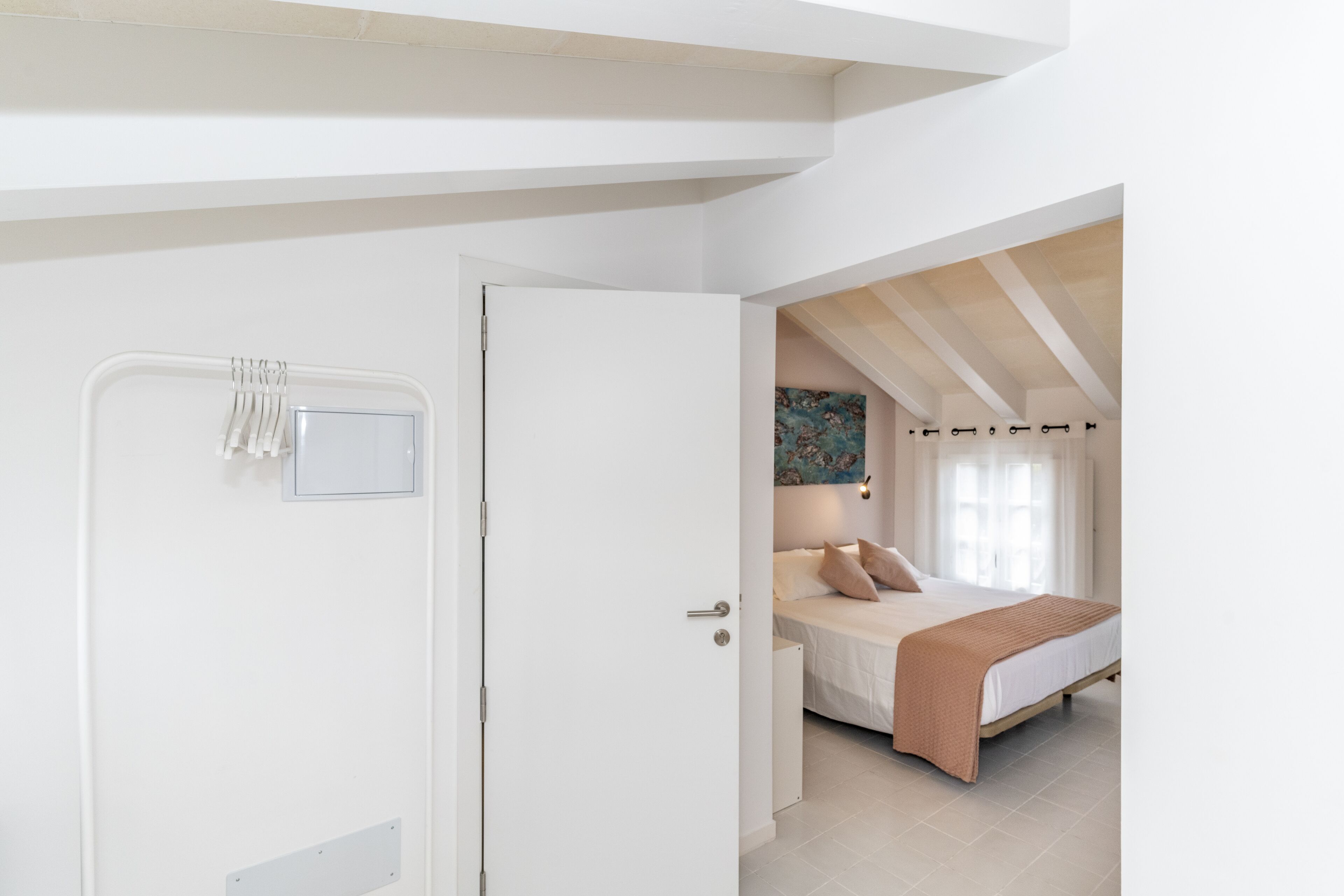 A bedroom with a bed, a nightstand, and a painting on the wall.