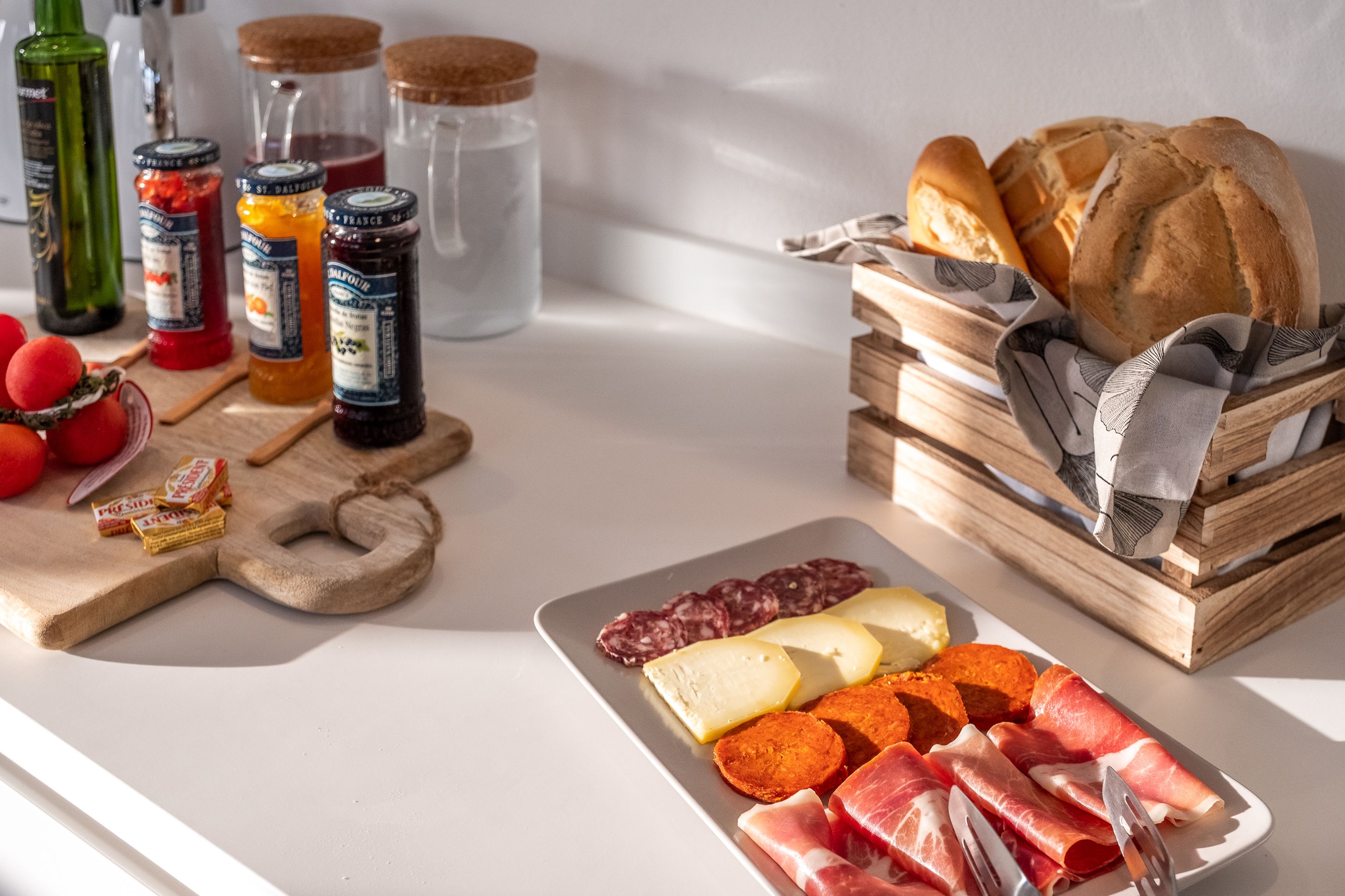 A charcuterie board with various meats, cheeses, and bread on a table.