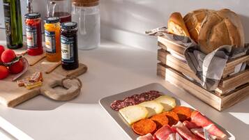 A charcuterie board with various meats, cheeses, and bread on a table.