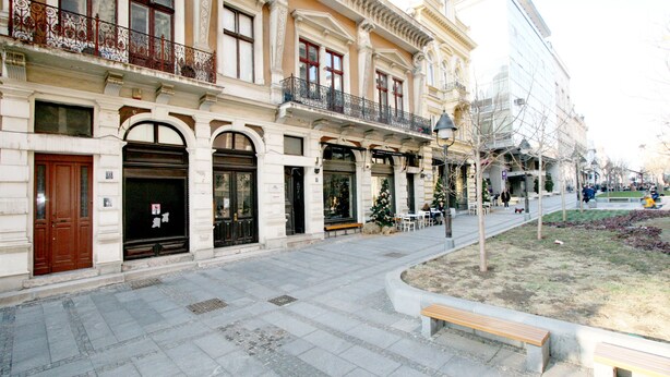 A street with a row of buildings featuring ornate balconies and large windows. - Apartment Manufactura (Belgrade)