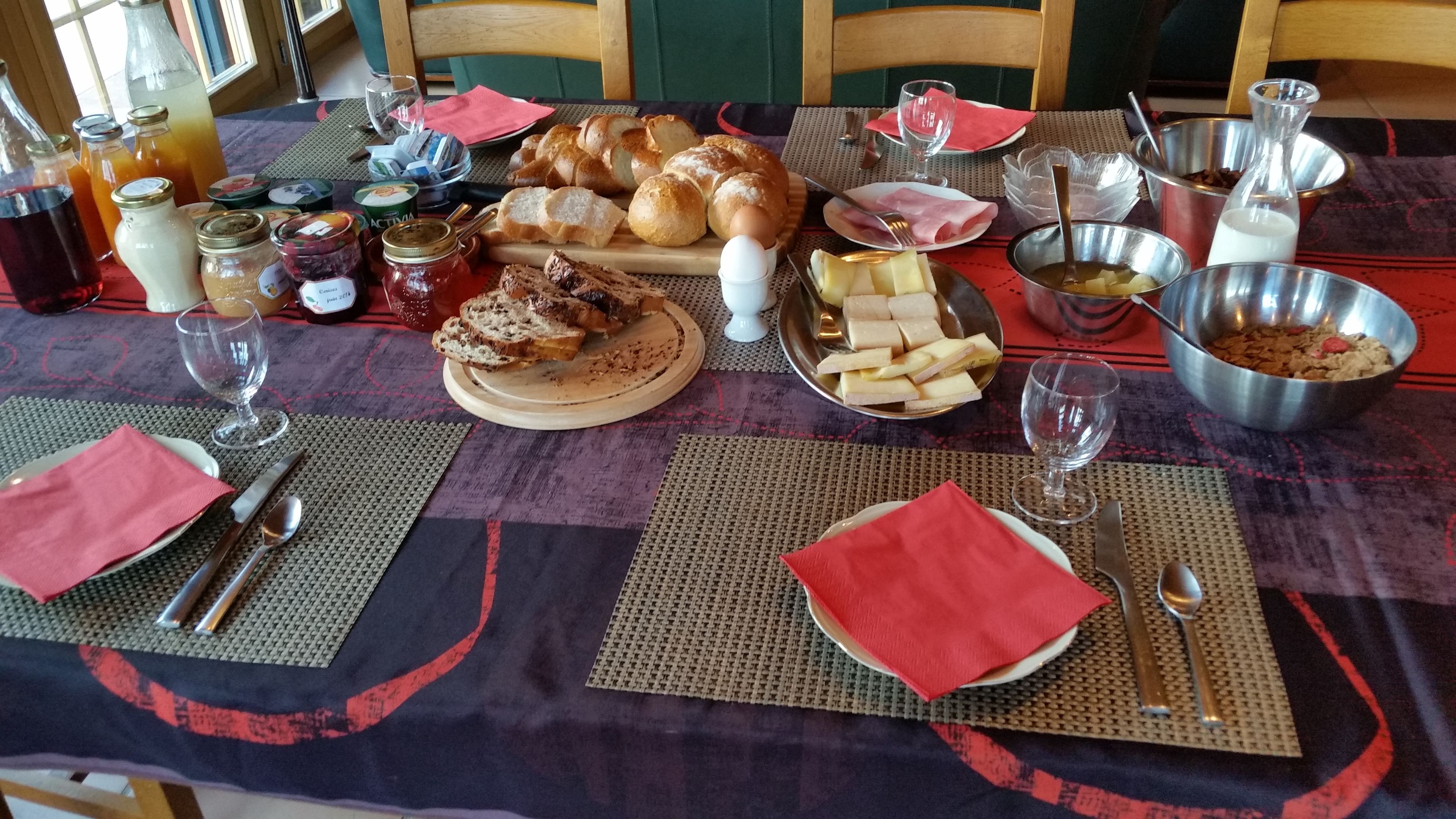 A dining table set with various food items, including bread, cheese, and condiments.