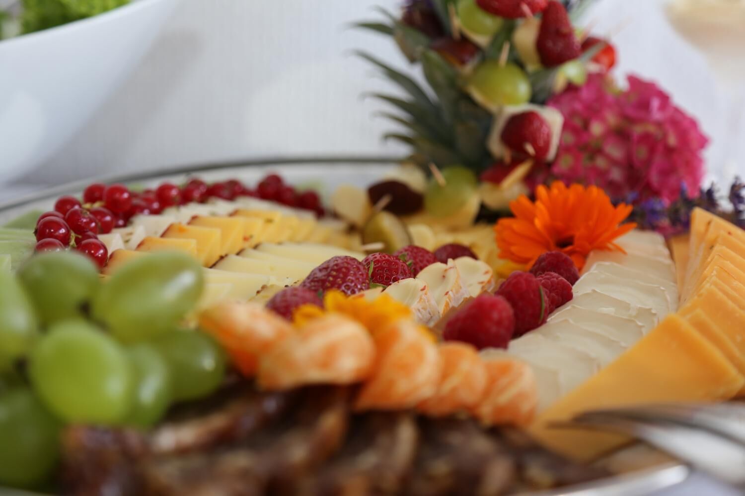 A platter of assorted cheeses and fruits.