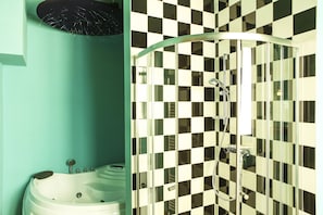 A bathroom with a checkered shower wall, a bathtub, and a green wall.
