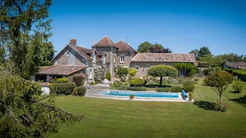 Una piscina al aire libre de temporada, sombrillas