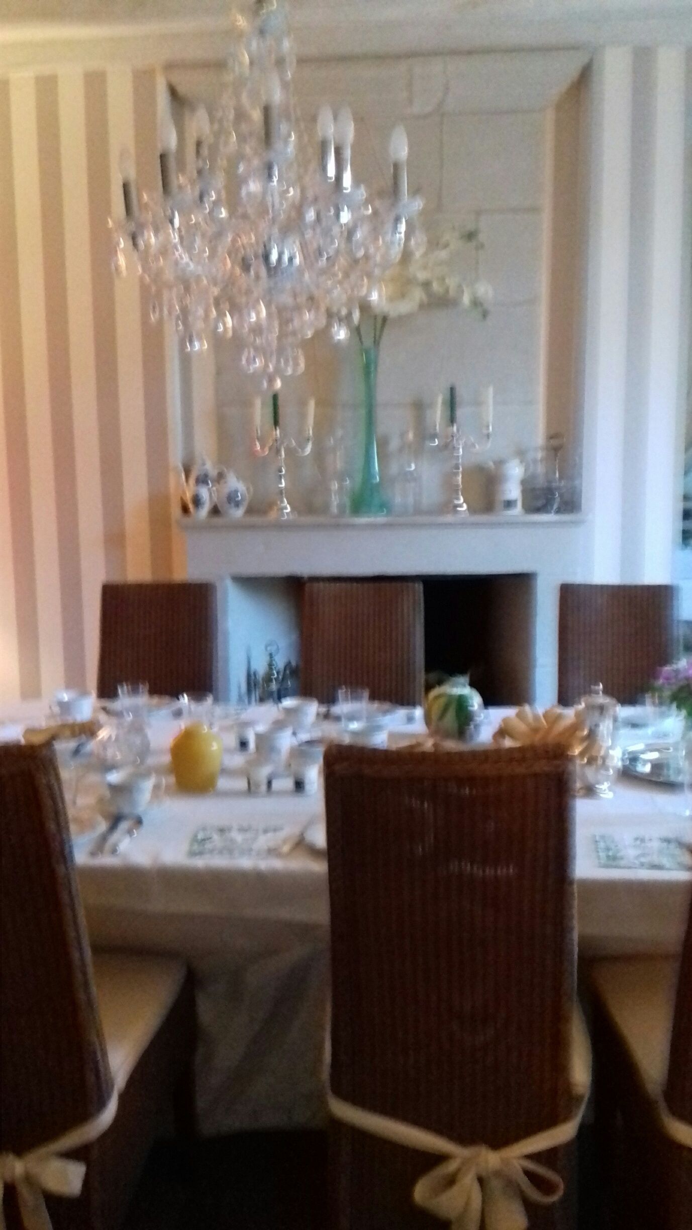 Una mesa de comedor dispuesta con platos, vasos y una pieza central.
