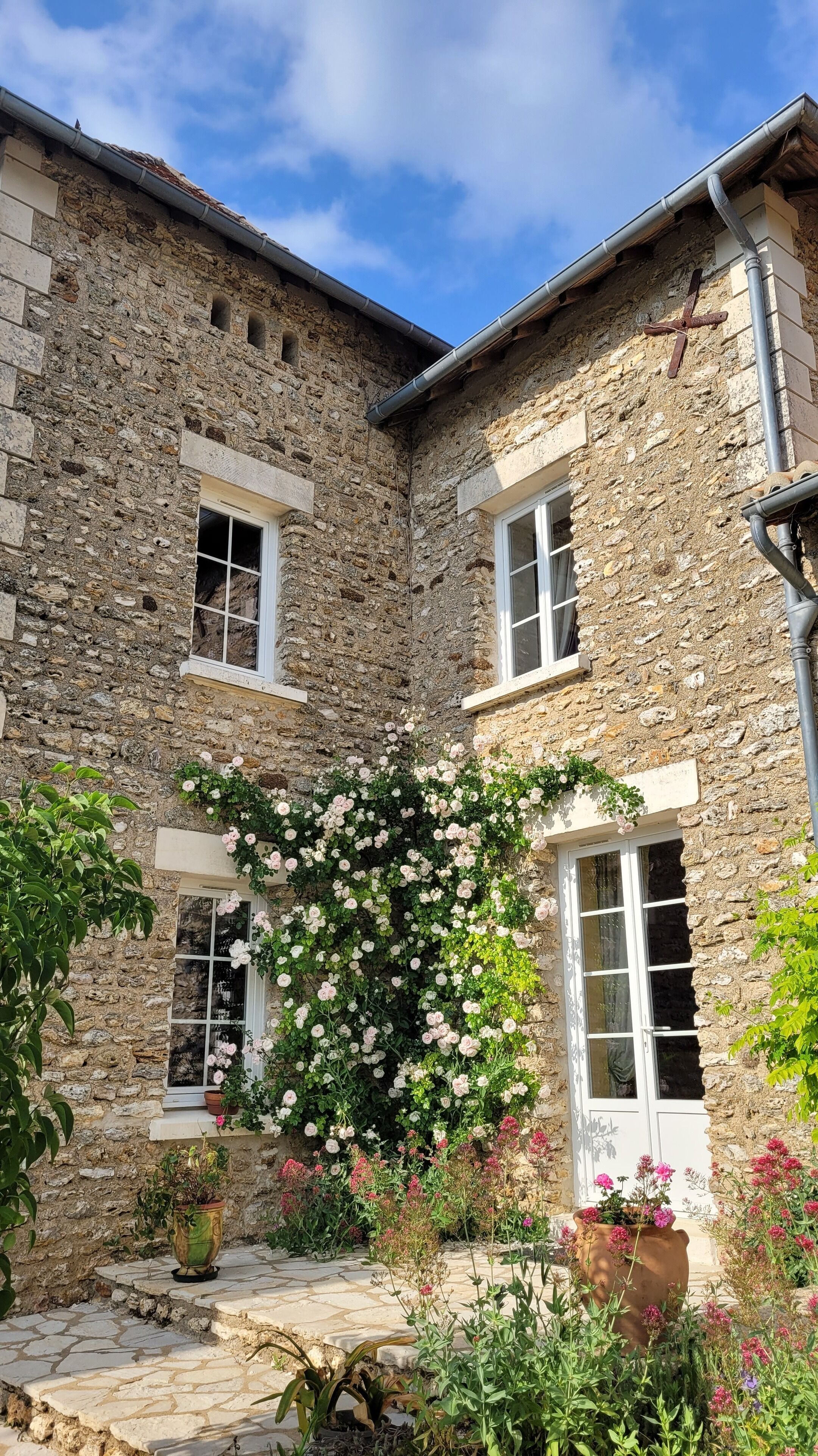 Un edificio de piedra con dos ventanas y una caja de flores.