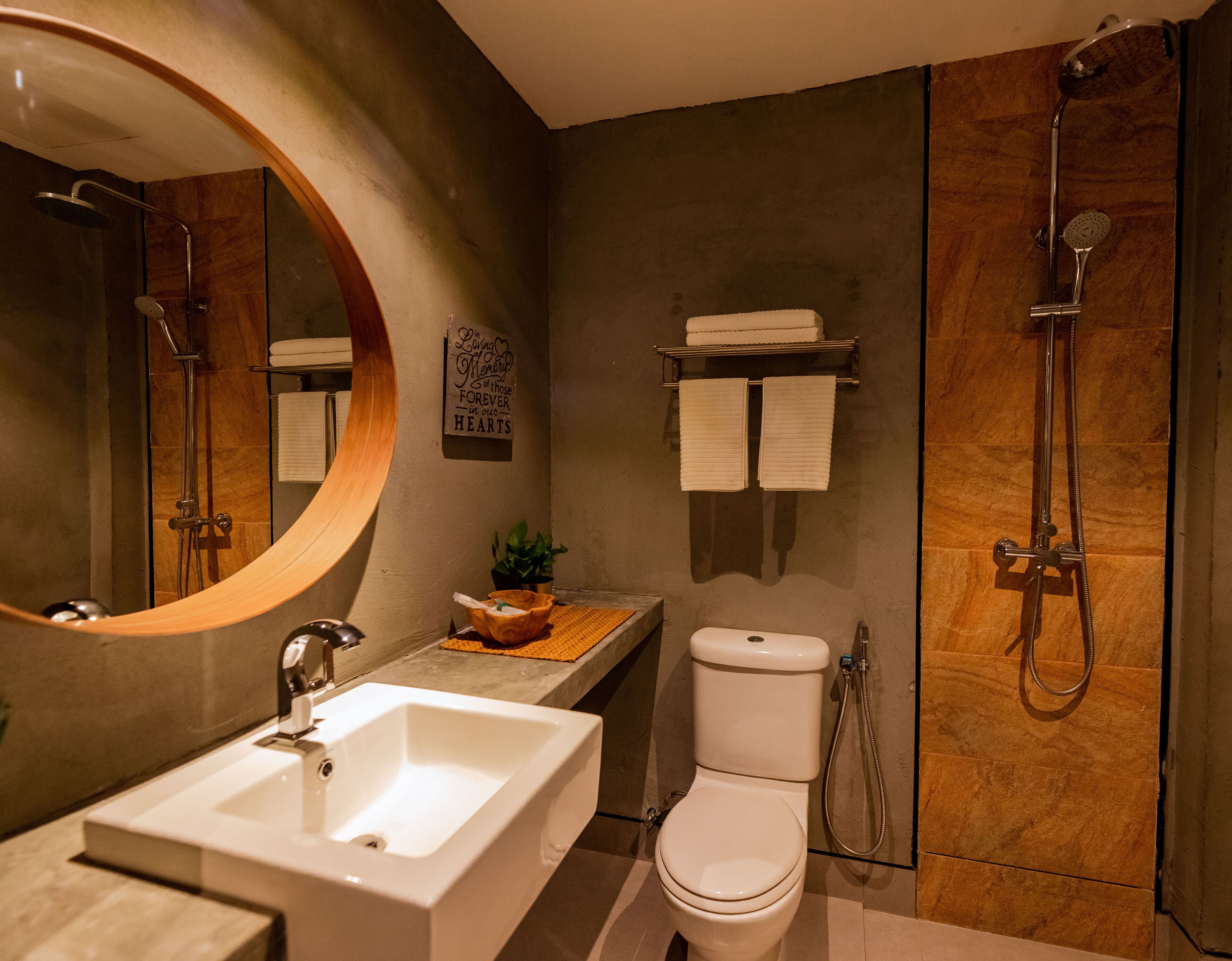 A modern bathroom with a large mirror, a sink, a toilet, and a shower.