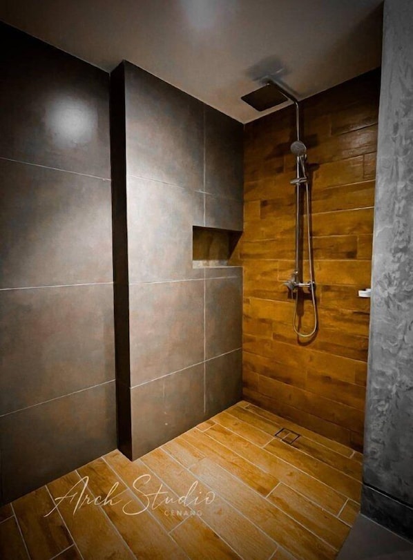 A modern shower with a wooden floor and dark tiles.
