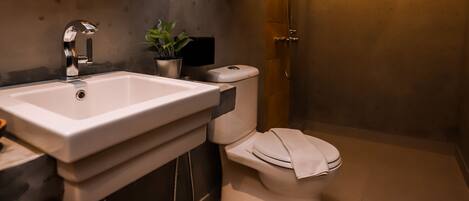A modern bathroom with a large mirror, a sink, a toilet, and a shower.