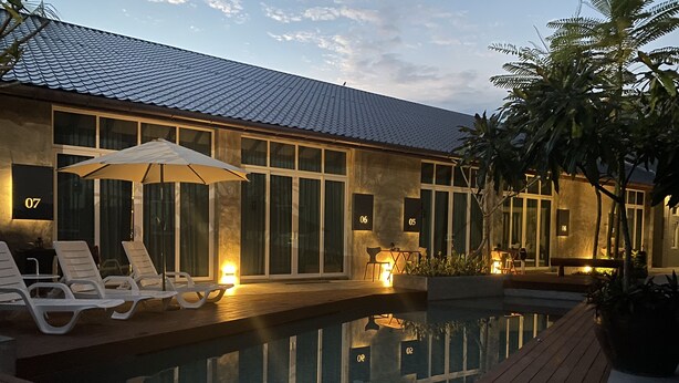 A modern pool area with lounge chairs and a wooden deck. - Arch Studio Cenang (Langkawi)