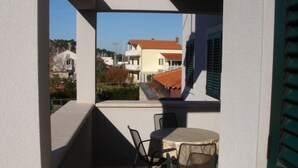 A balcony with a table and chairs, overlooking a residential area with houses and trees. - Holiday Home in Betina with Seaview, Terrace, Air condition, WIFI (4671-1) (Betina)