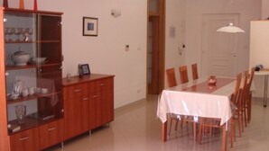 A dining area with a table set for four, a wooden cabinet with glass doors, and a white ceiling light. - Holiday Home in Betina with Seaview, Terrace, Air condition, WIFI (4671-1) (Betina)