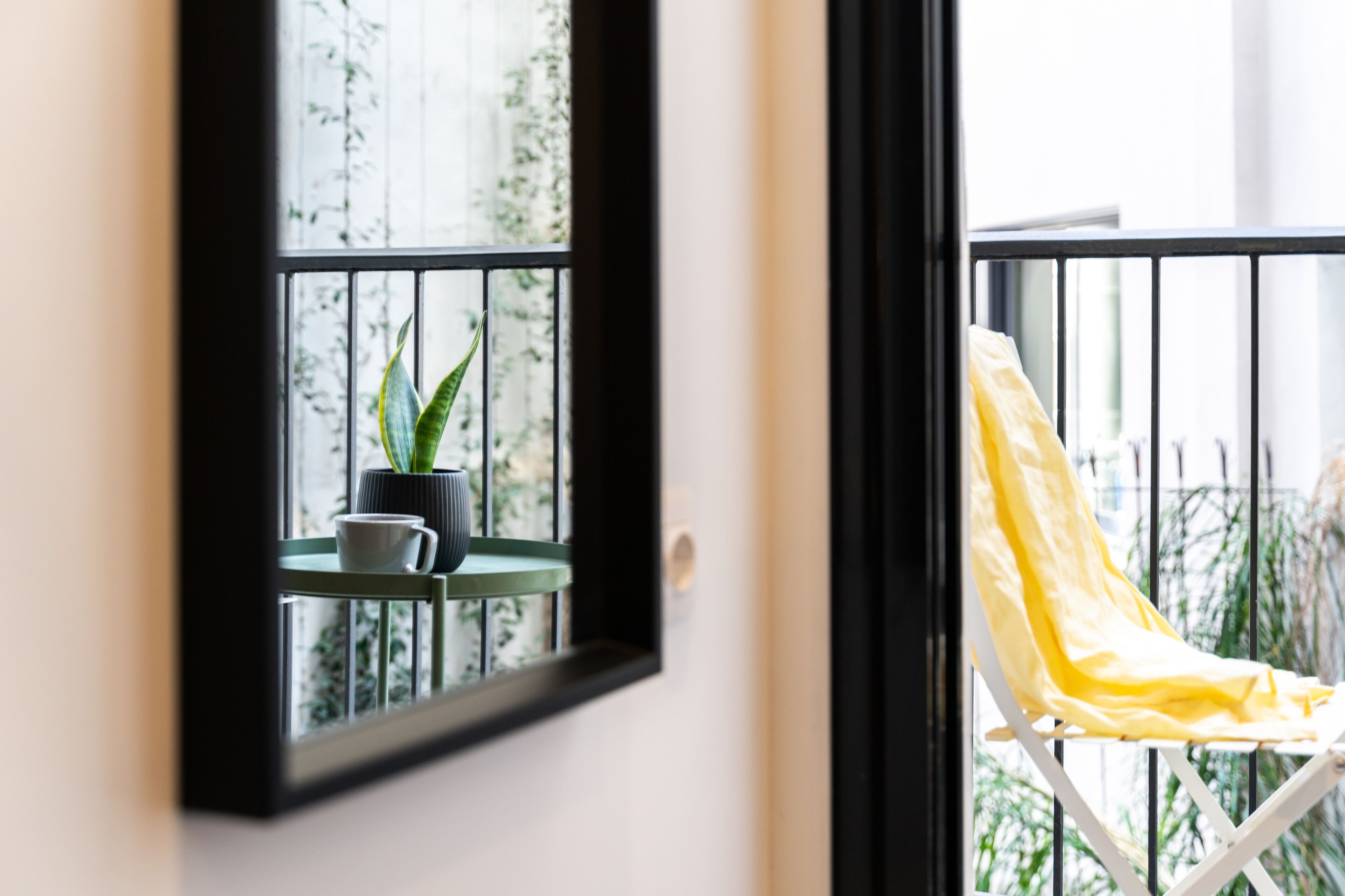 A balcony with a chair and a potted plant.