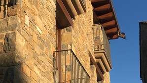 A stone building with a balcony and a window. - Hotel Los Arcos (Ainsa)