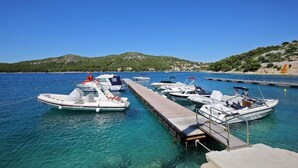 Un port de plaisance où plusieurs bateaux sont amarrés à un quai en bois.