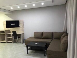 Habitación Deluxe con 1 cama matrimonial o 2 individuales, 1 cama King size | Área de sala de estar | Televisión de pantalla plana de 32 pulgadas con canales vía satélite 