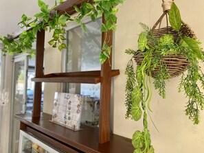 Una estructura de madera con un tablero de menú y plantas verdes colgantes.