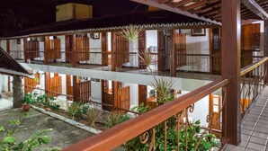 A multi-level building with wooden balconies, potted plants, and a tiled floor. - Chaua Porto Hotel (Porto Seguro)