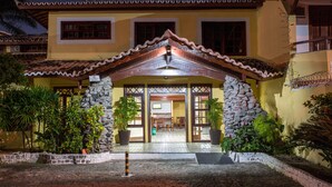 A building with a stone facade, a tiled entrance, and potted plants. - Chaua Porto Hotel (Porto Seguro)