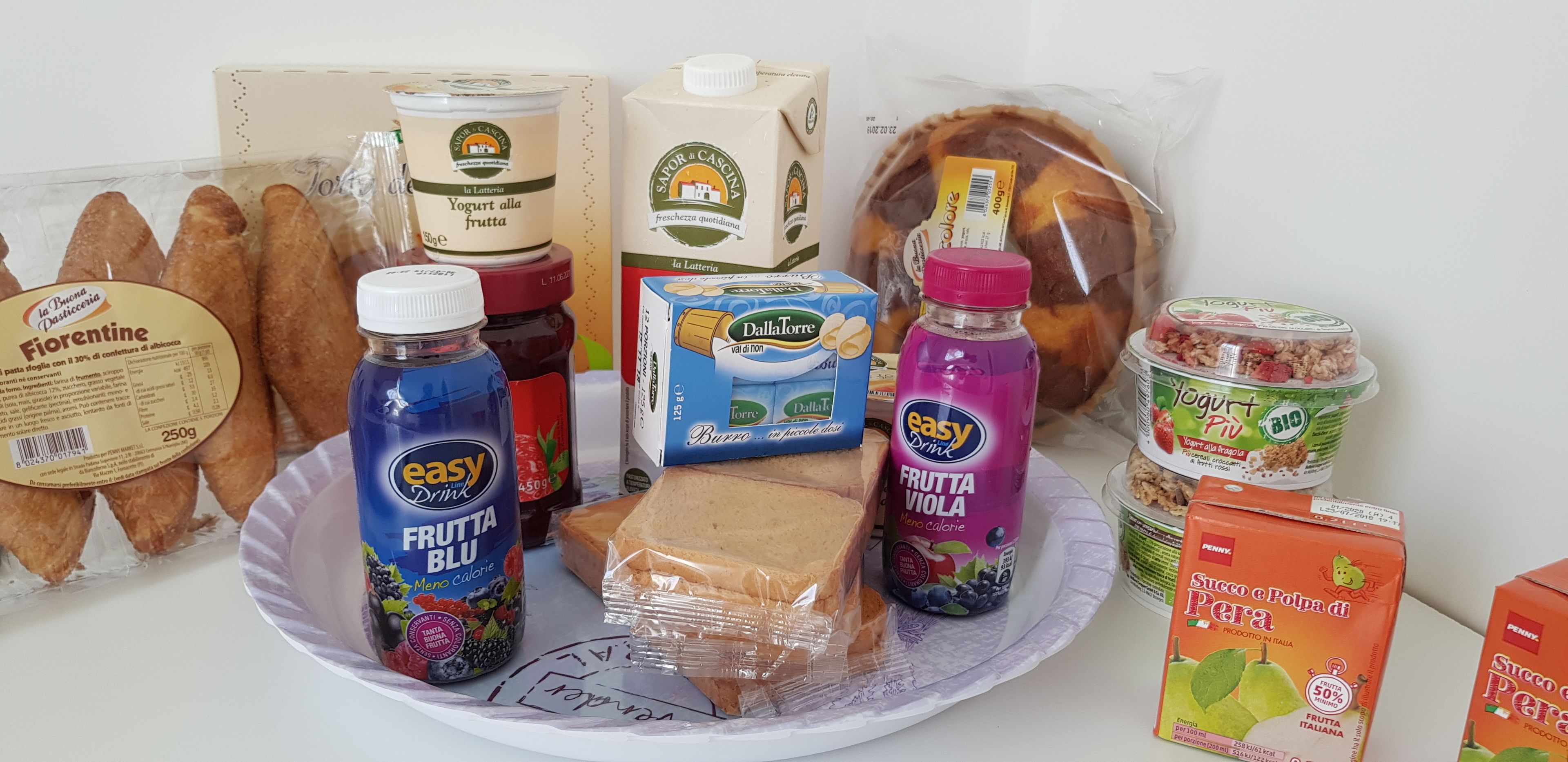 A variety of food items including bread, yogurt, and juice on a plate.