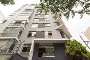 Un edificio moderno de varios pisos con ventanas grandes y balcones.