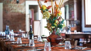 A dining table set with clear glasses, cutlery, and a centerpiece of flowers and greenery. - Mulino Delle Valli (Casaleone)